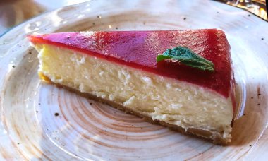 Kiraz jöleli soğuk peynirli kek ve yeşil nane yaprağı..