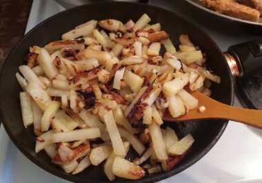 Kızarmış patates ve soğanlı ev yapımı, doyurucu bir yemek tavası..