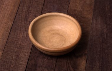 Tahta bir yüzey üzerinde kırmızı kil tabağı, üst görünüm.