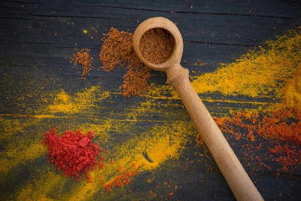 Wooden Spoon Paprika Scattered Yellow Red Spices Black Wooden Background — Stock Photo, Image