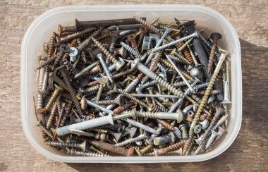 Atölyede eski çiviler paslı vidalar ve diğer bağlayıcılarla dolu bir kutu..