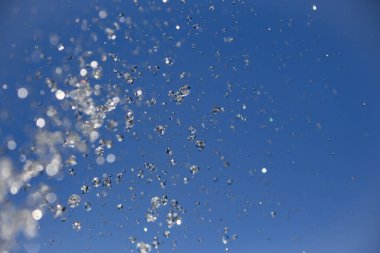 Mavi gökyüzüne doğru parlak bir su damlası.