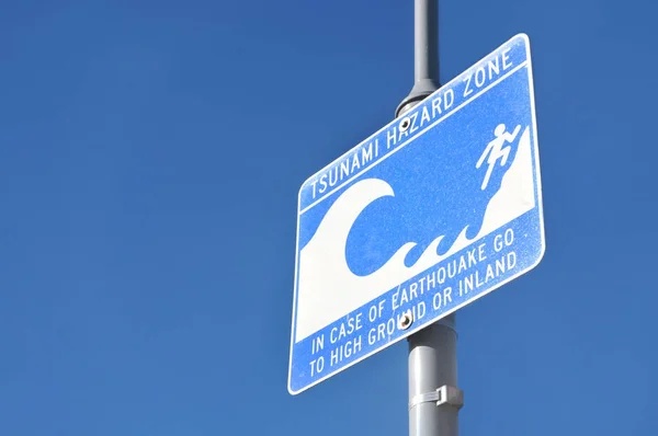 Panneau d'avertissement de zone de risque de tsunami sur ciel bleu — Photo