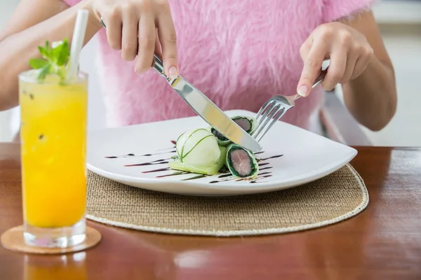 Woman eat crunchy tuna spring roll with cucumber ice cream. Mole