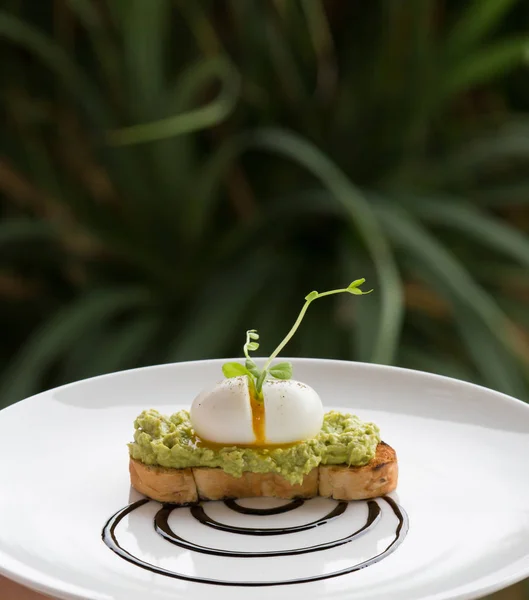 Pochiertes Ei, zertrümmerte Avocado auf Toast. Haute Cuisine — Stockfoto