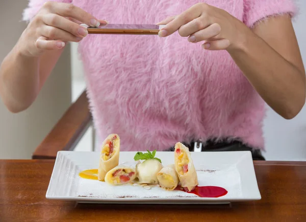 Woman taking picture of dessert with her phone