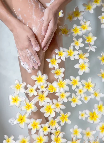 Piernas de mujer en tubo de baño con flores spa relajación cuidado corporal th —  Fotos de Stock