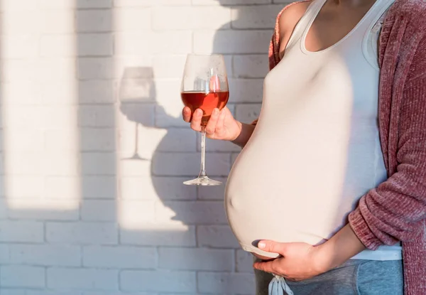 Mulher grávida com copo de vinho tinto na mão — Fotografia de Stock