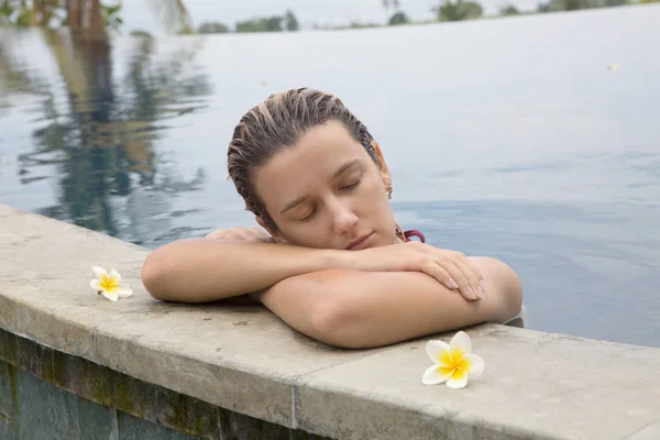 Mooie jonge vrouw te leggen en te ontspannen in de buurt van zwembad — Stockfoto