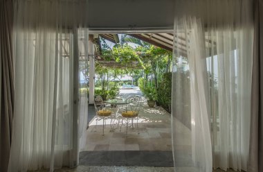 Plajda perdeler üzerinden deniz manzaralı. Güzel manzara tatil köyü, tropik tatil kavramı gevşeme yatak odasından arıyorum