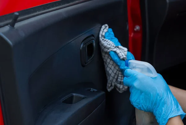 Czyszczenie wnętrza samochodu i spryskiwanie cieczą dezynfekcyjną. Ręce w gumowej rękawicy ochronnej dezynfekującej wnętrze gałki ocznej w celu ochrony przed koroną wirusa — Zdjęcie stockowe