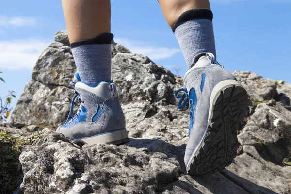 Primer plano de botas de senderismo y piernas trepando por sendero rocoso — Foto de Stock