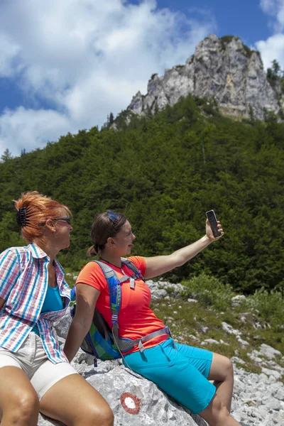 Duas mulheres bonitas fotografando uma selfie no pico da montanha — Fotografia de Stock