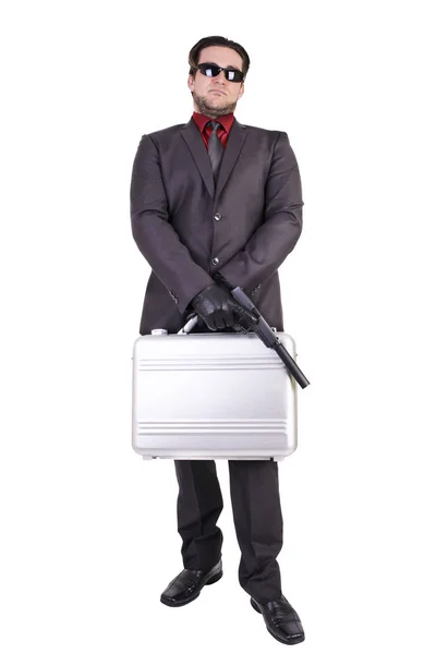 Knappe man houden pistool en koffer — Stockfoto