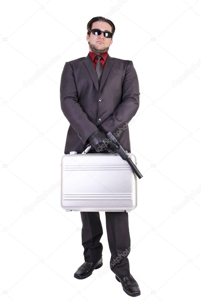 Handsome man holding gun and suitcase