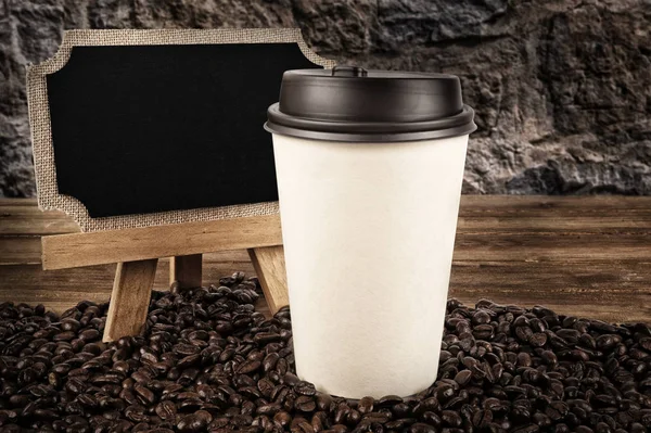 一杯のコーヒーと古い木製の背景のコーヒー豆 側の黒板 ストック写真