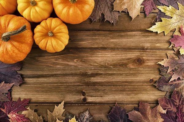 木製の背景に紅葉とカボチャ トップ ビュー — ストック写真