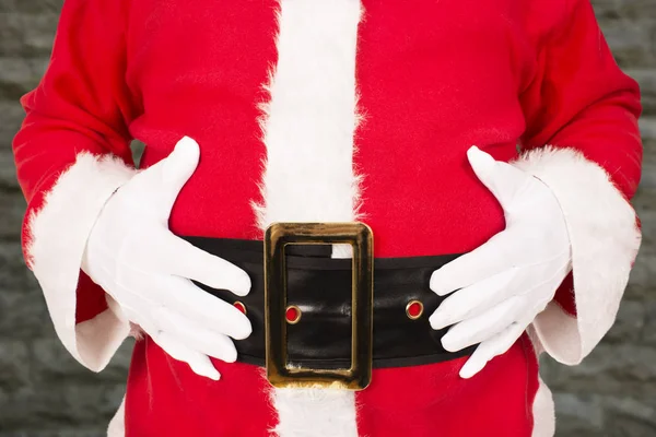 Fechar Papai Noel Segurando Sua Barriga Parede Tijolo Fundo — Fotografia de Stock