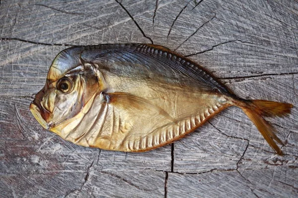 Savustettu kala puupöydällä, oksennus — kuvapankkivalokuva