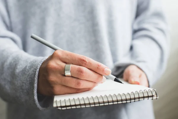 Vrouw hand schrijven in papieren notitieblok. — Stockfoto