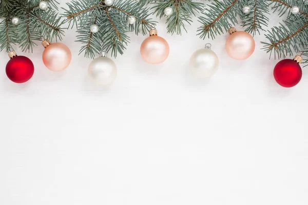 Bolas de Navidad, perlas, abeto en la parte superior de la textura de madera blanca — Foto de Stock