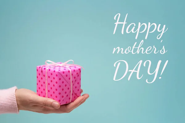 Buona festa della mamma biglietto di auguri con la mano della donna e scatola regalo . — Foto Stock