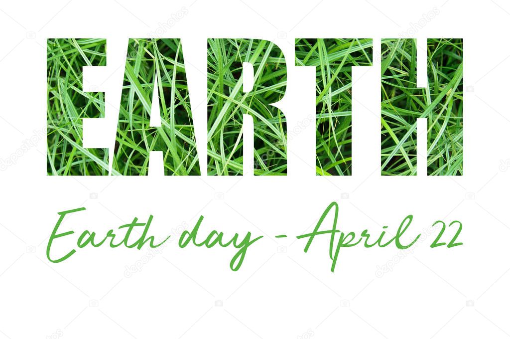 Concept card with Earth Day inscription on green grass. 