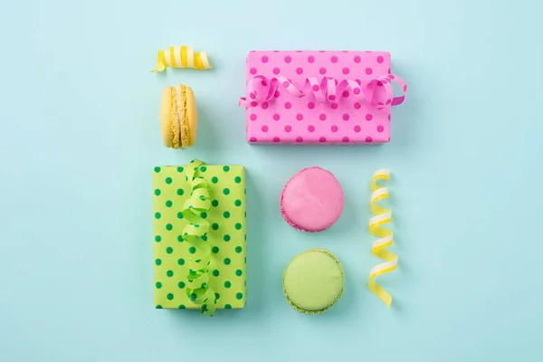 Festliche flache Liege mit Geschenkschachteln & bunten Macarons auf hellem Bl lizenzfreie Stockbilder