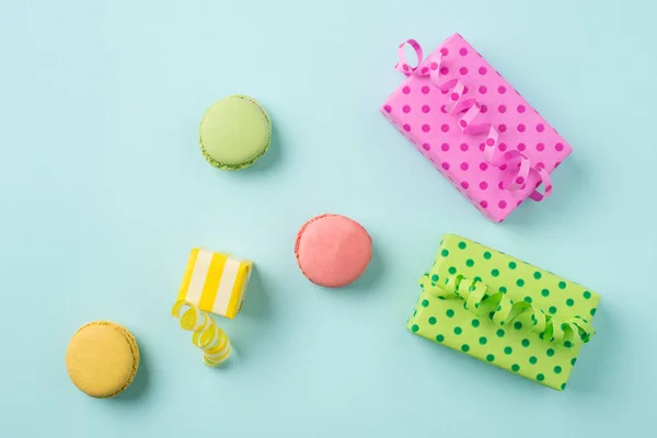Festlich abstrakte flache Liege mit bunten Geschenken & Macarons auf Licht lizenzfreie Stockfotos