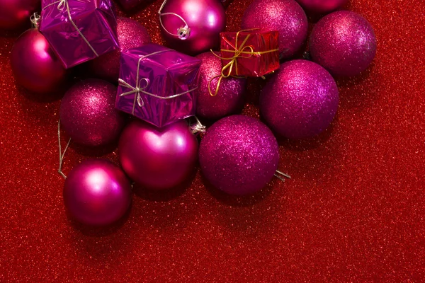 Dárky a vánoční ozdoby na červeném pozadí — Stock fotografie
