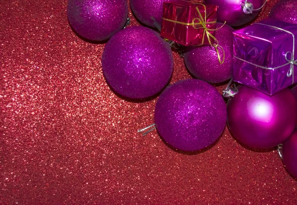 Подарки и рождественские украшения на красном фоне — стоковое фото