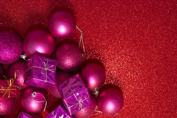 Подарки и рождественские украшения на красном фоне — стоковое фото