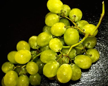 Siyah bir kayrak taş üzerinde üzüm demet