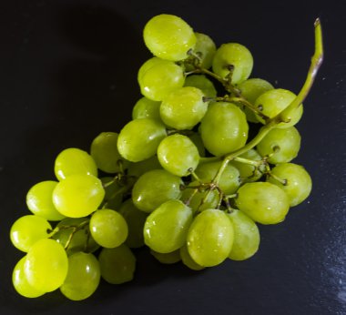 Siyah bir kayrak taş üzerinde üzüm demet