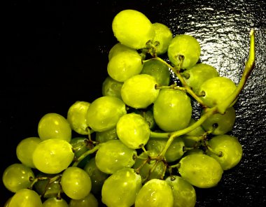 Siyah bir kayrak taş üzerinde üzüm demet