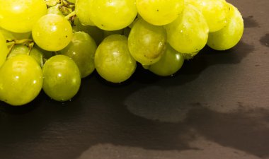 Siyah bir kayrak taş üzerinde üzüm demet