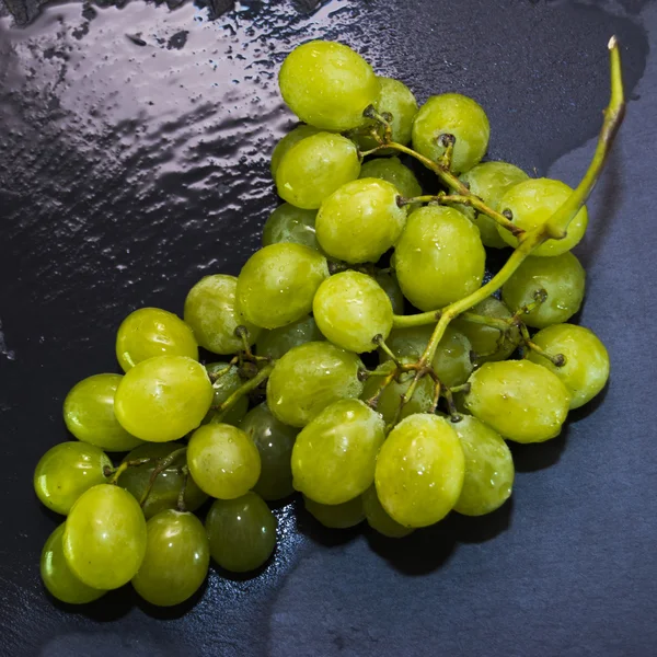 Bouquet de raisins sur une pierre d'ardoise noire — Photo