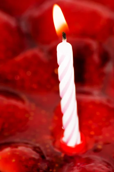 Bolo de morango, amêndoas e nata com uma vela em um backgr vermelho — Fotografia de Stock