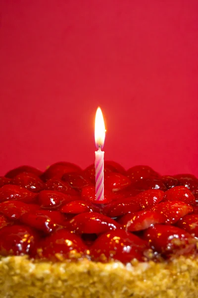 Torta di fragole, mandorle e panna con candela su dorso rosso — Foto Stock