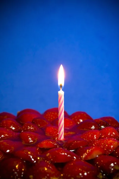 Клубничный торт, миндаль и сливки со свечой на голубом рюкзаке — стоковое фото