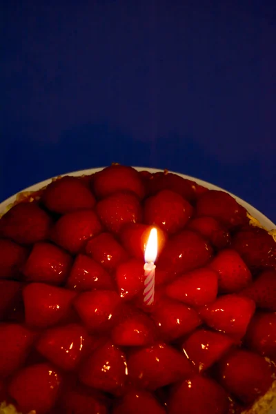 Клубничный торт, миндаль и сливки со свечой на голубом рюкзаке — стоковое фото