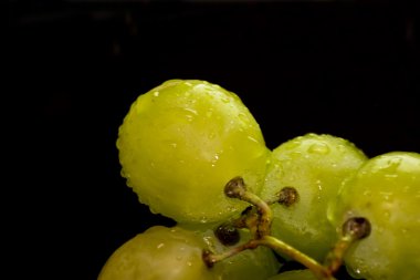 Siyah bir kayrak taş üzerinde üzüm demet