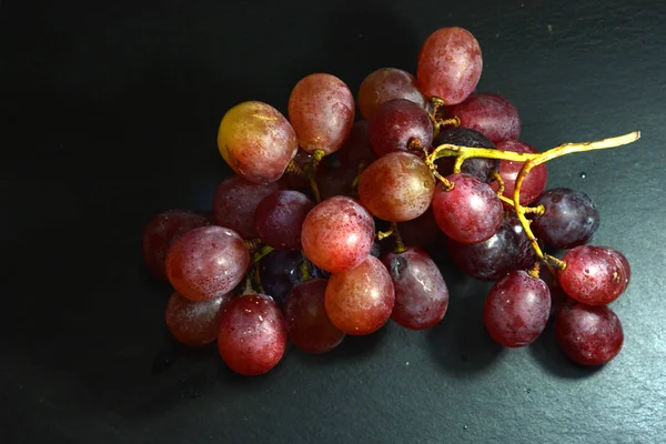 Куча винограда на каменной доске — стоковое фото