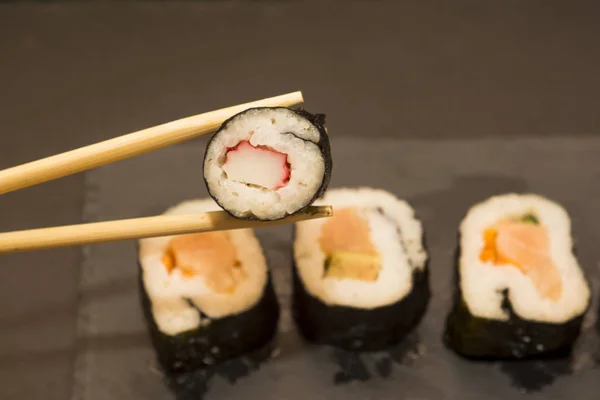 Pedaços de sushi em uma pedra preta — Fotografia de Stock