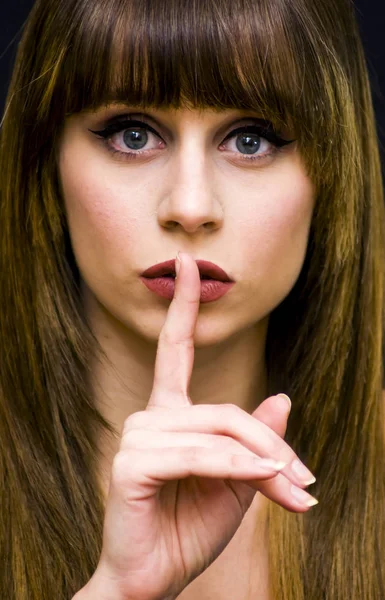 Skönhet kvinna stående befallande tystnad med en finger gest — Stockfoto