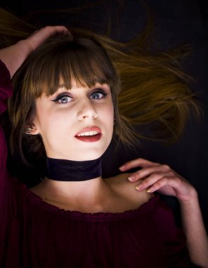 Güzellik kadını siyah arka plan üzerinde uzanmış