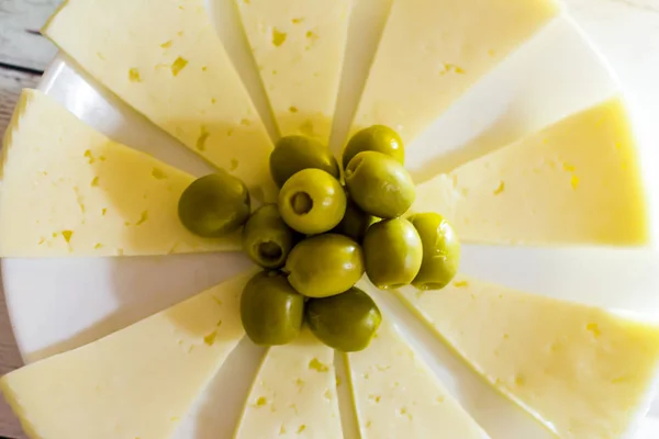 Cheese with olives. Healthy food on a white wooden table — Stock Photo, Image