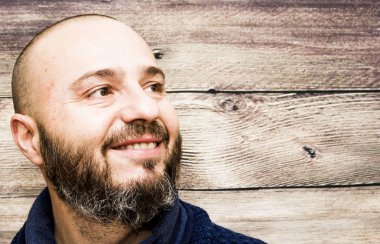 Ahşap arka plan üzerinde sakallı yakışıklı, kel adam