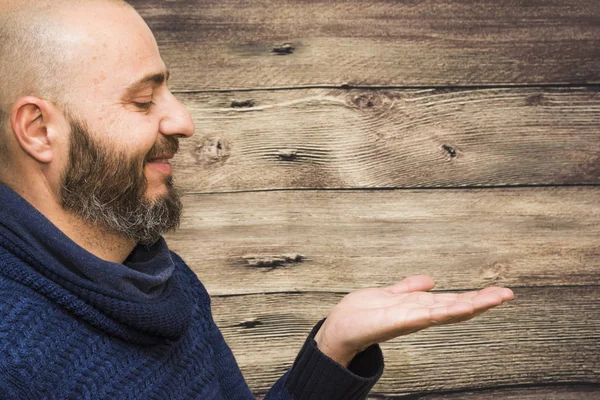 Bello, calvo uomo con la barba con la mano aperta su un legno — Foto Stock