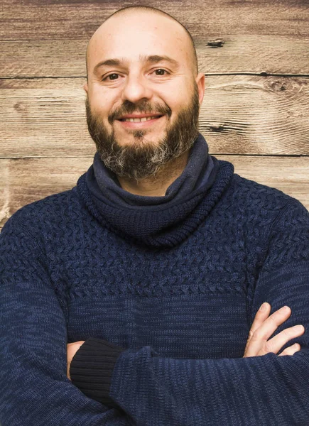 Bonito, homem careca com barba em um fundo de madeira — Fotografia de Stock